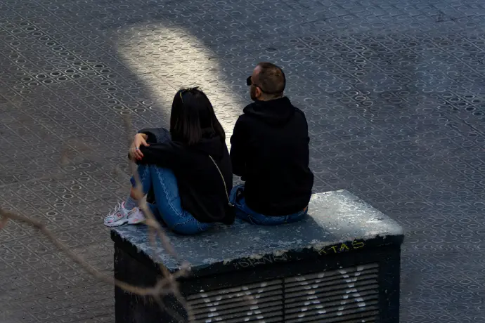 A couple of people sitting on top of a bench