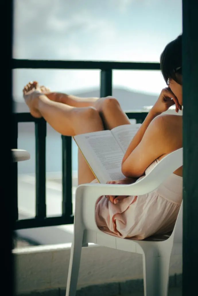 a woman sitting in a chair reading a book